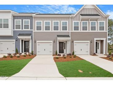 Attractive townhomes with a pleasing color scheme, well-kept landscaping, and individual garages for each unit at 116 Fideaux Blvd # 258, Raleigh, NC 27603