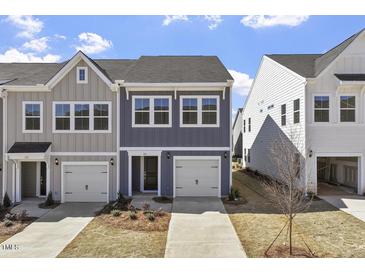 Charming gray and blue townhome featuring a front-entry garage and well manicured lawn at 119 Central Townes Way # 301, Raleigh, NC 27603