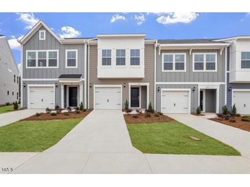 A row of newly built townhomes feature individual garages and well-maintained front yards at 128 Fideaux Blvd # 255, Raleigh, NC 27603
