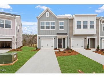 Charming townhomes with attached garages and well-maintained lawns create an inviting curb appeal at 132 Fideaux Blvd # 254, Raleigh, NC 27603
