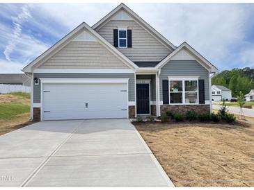 Charming single-Gathering home with a two-car garage and manicured lawn, presenting a welcoming facade at 142 Vega Loop, Sanford, NC 27330