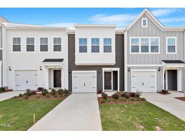 New construction townhome showcasing a modern facade, attached garages, and manicured lawns at 144 Fideaux Blvd # 251, Raleigh, NC 27603