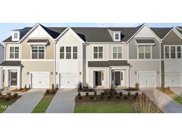 Four townhouses with neutral siding, two-car garages, and landscaping at 21 Nettle Ln # 252, Clayton, NC 27520