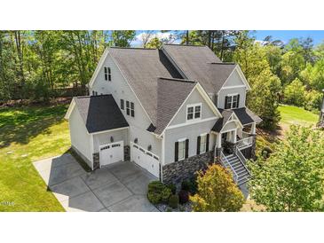An upscale two-story home featuring a 2-car garage and a beautifully landscaped yard with trees at 3308 Eden Grove Rd, Fuquay Varina, NC 27526