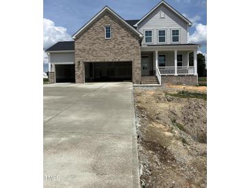 New two-story home with a two-car garage, brick accents, and a charming front porch at 54 Cultivator Ct, Angier, NC 27501