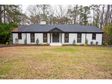Charming brick home with black trim, a manicured front lawn, and mature trees at 72 Beverly Dr, Durham, NC 27707