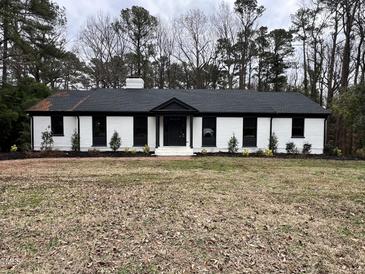 White brick ranch house with black accents, landscaped yard at 72 Beverly Dr, Durham, NC 27707