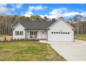 Charming white home with a two-car garage, a cozy front porch, and a well-maintained lawn at 9342 Turkey Way, Middlesex, NC 27557
