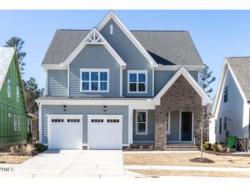 Charming two-story home with a two-car garage, brick accent, and manicured lawn at 121 Big Bradley Way, Wendell, NC 27591