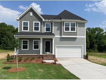 Charming two-story home featuring a well-manicured lawn and a classic architectural design at 139 Grove Township Way, Angier, NC 27501