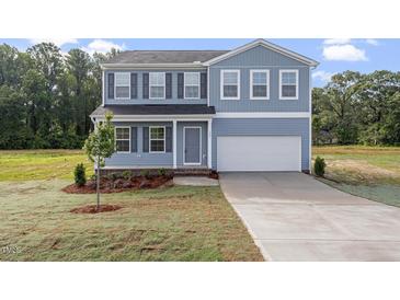 Charming two-story home with blue siding, black shutters, and a well-maintained front yard at 157 Grove Township Way, Angier, NC 27501