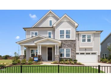 Two-story house with gray siding, stone accents, and a two-car garage at 204 E Fountainhead Ln, Garner, NC 27529