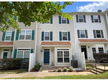 Tan three-story townhouse with teal front door and white fence at 2221 Valley Edge Dr # 105, Raleigh, NC 27614
