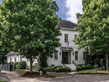 Stately two-story brick home featuring an American flag, manicured landscaping and a charming entrance at 2900 Glenanneve Pl, Raleigh, NC 27608