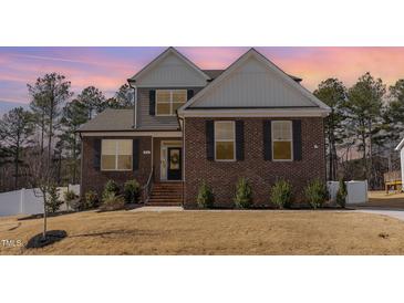 Charming brick home featuring manicured landscaping, a welcoming entrance, and a well-maintained lawn at 40 Ironwood Blvd, Youngsville, NC 27596