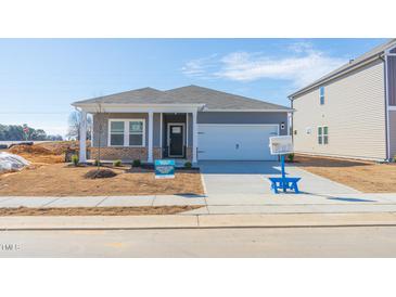 Gray house with white garage door and landscaping at 441 White Birch Ln, Angier, NC 27501