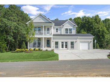 Stunning two-story home featuring a double-decker porch, well-manicured lawn, and a spacious three car garage at 125 Charlotte Knoll St # 15, Zebulon, NC 27597