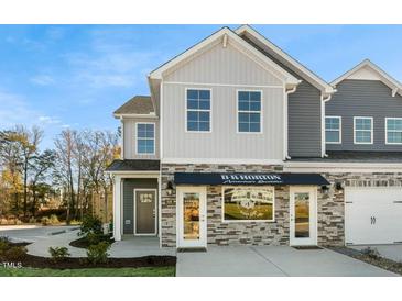 Two-story townhome with gray siding, stone accents, and a covered entryway at 2330 Sugar Cone Way, Fuquay Varina, NC 27526