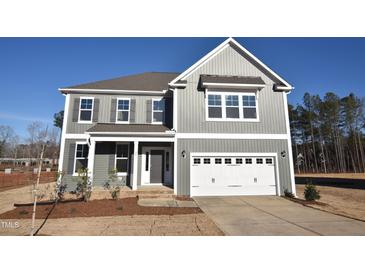 Charming two-story home featuring a two-car garage and classic gray siding at 25 Accord Dr, Youngsville, NC 27596