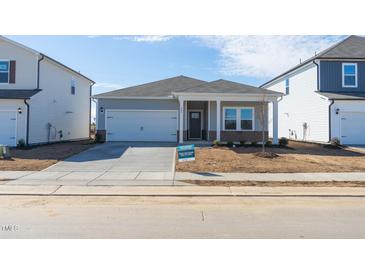 Newly constructed home with gray siding, brick accents, and a covered porch at 483 White Birch Ln, Angier, NC 27501