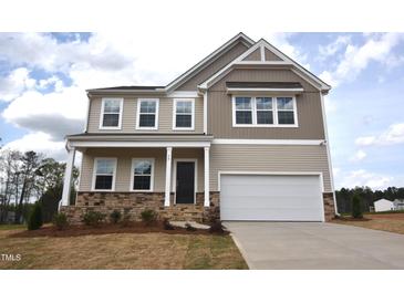 Charming two-story home featuring a two-car garage, stone accents, and a welcoming front porch at 50 Cordoba Dr, Franklinton, NC 27525
