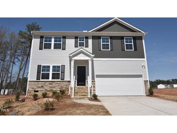 Charming two-story home with a mix of stone and siding, plus a two-car garage and nicely manicured lawn at 60 Cordoba Dr, Franklinton, NC 27525