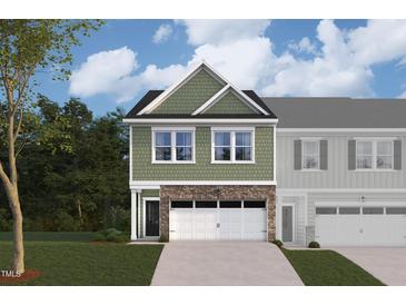Two-story townhome with green siding, stone accents, and a two-car garage at 7125 Hubner Pl # 24, Cary, NC 27519