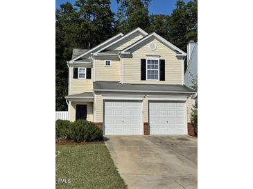 Two-story house with double garage and landscaped yard at 7309 Brighton Hill Ln, Raleigh, NC 27616