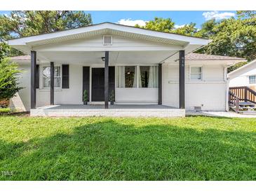 White brick ranch house with covered porch and landscaped lawn at 816 Peyton St, Raleigh, NC 27610