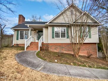 Brick and siding ranch home with a landscaped yard and walkway at 3321 Beech Bluff Ln, Raleigh, NC 27616