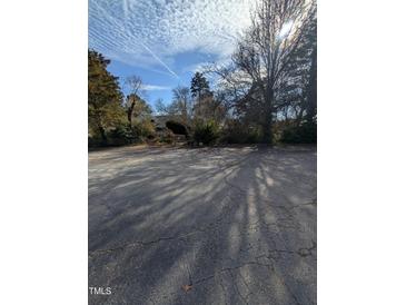 Spacious parking lot with mature trees surrounding the property at 4053 Little Creek Church Rd, Clayton, NC 27520