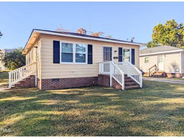 Cute yellow house with white steps and a well-maintained lawn at 509 Mullins St, Rocky Mount, NC 27803