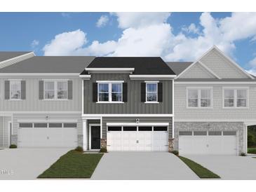 Two-story townhome with gray siding, white garage doors, and landscaping at 7129 Hubner Pl # 26, Cary, NC 27519