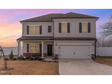 Two-story home featuring a front-facing two-car garage, gray siding, and dark shutters at 108 Bonnie Girl Ct, Lillington, NC 27546