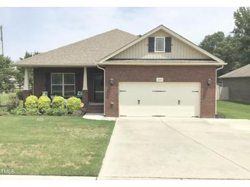 Brick ranch home with attached garage and manicured lawn at 2001 Bunnfield Dr, Zebulon, NC 27597