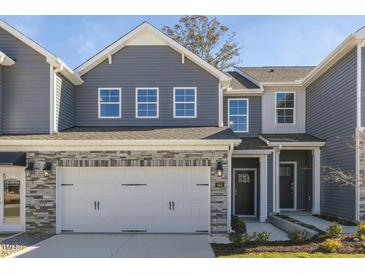 Gray townhome with stone accents, two-car garage, and landscaping at 2328 Sugar Cone Way, Fuquay Varina, NC 27526