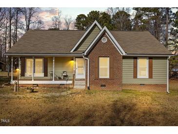 Charming single-story home with a brick facade, covered porch, and cozy curb appeal at 521 N Franklin Dr, Sanford, NC 27330