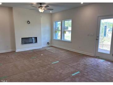 Bright living room with a fireplace and windows letting in plenty of natural light at 7115 Hubner Pl # 21, Cary, NC 27519