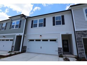 New construction townhouse featuring white siding, a two-car garage and decorative black shutters at 7117 Hubner Pl # 22, Cary, NC 27519
