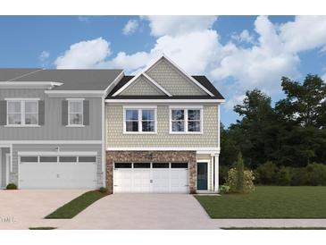 Two-story townhome with gray siding, stone accents, and a two-car garage at 7119 Hubner Pl # 23, Cary, NC 27519