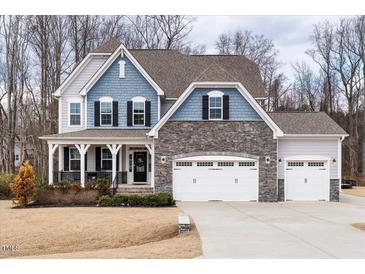 Two-story house with gray and blue siding, stone accents, and a three-car garage at 804 Peterson Ridge Rd, Fuquay Varina, NC 27526