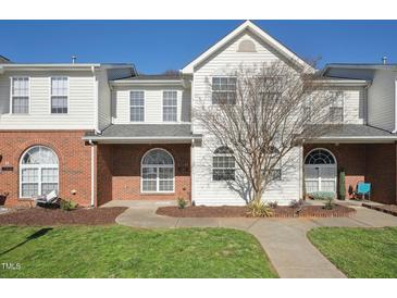 Charming townhome featuring a well-maintained lawn, brick accents, and inviting curb appeal at 2031 Rivergate Rd # 105, Raleigh, NC 27614