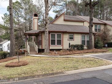 Tan two-story house with red trim, landscaped yard, and walkway at 5101 Hogans Way, Clayton, NC 27520