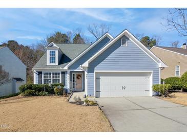 Charming home featuring a well-manicured lawn, blue siding, and an attached two-car garage at 701 Brickstone Dr, Apex, NC 27502