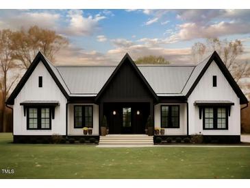 Stunning modern farmhouse with black and white exterior, landscaping, and large windows at Lot 18H Good Shepherd Trl, Spring Hope, NC 27882