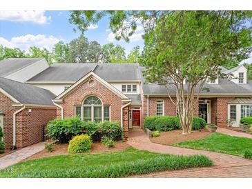 Beautiful brick home with a well-manicured lawn and mature trees on a sunny day at 3347 Ridgecrest Ct, Raleigh, NC 27607
