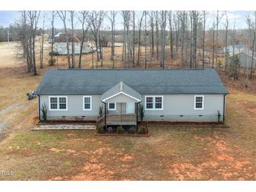 Single-story home with gray siding, a covered porch, and a large yard at 5724 Walters Ln, Burlington, NC 27217