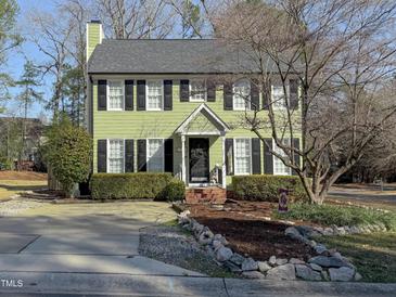 Two-story home featuring black shutters, a manicured lawn, and a driveway at 1700 Southern Hills Ct, Raleigh, NC 27604