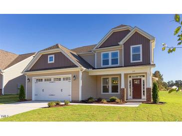 Charming two-story home features a manicured lawn and attached two-car garage at 359 Ballast Pt, Clayton, NC 27520