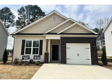 Charming single-story home features a brick-accented garage and neutral color palette at 394 Maidenhair Pl, Clayton, NC 27520